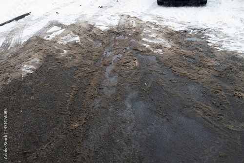 Semi melted snow mud at asphalt parking lot road winter photo