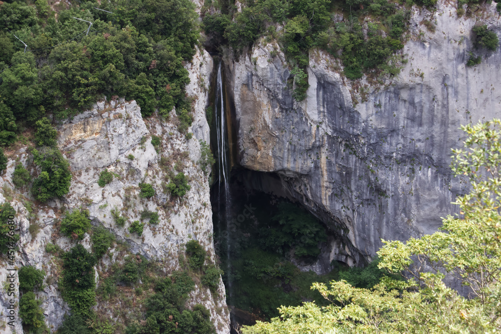 Vue sur la cascade de Courmes depuis le sentier de l'aqueduc de gourdon par un trou dans la roche