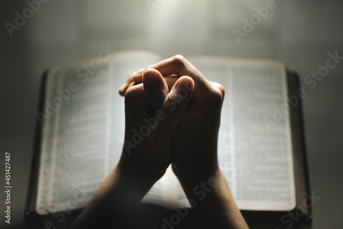 Women pray from god blessing to have a better life. Women hands praying to god with the bible. believe in goodness. Holding hands in prayer on a wooden table. Christian life crisis prayer to god.