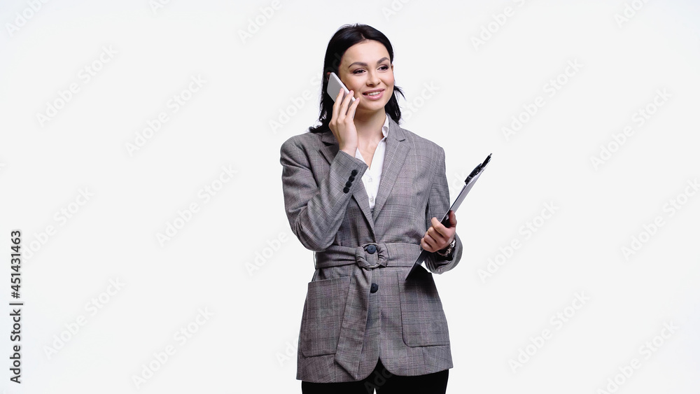 Woman in formal wear holding clipboard and talking on smartphone isolated on white. Woman in formal wear holding clipboard and talking on smartphone isolated on white.