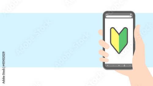 ネットで検索する初心者・スマホデビューのイメージ素材：スマートフォンを持つ人の手と初心者マークのアイコン入り画面 - HD16:9比率