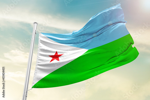 Djibouti national flag waving in beautiful clouds.