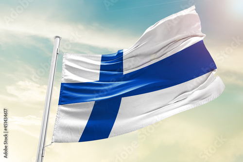 Finland national flag waving in beautiful clouds.