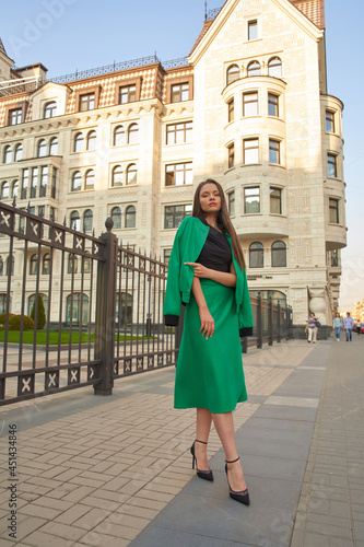 Stylish fashionable girl wearing trendy green costume posing at city street © Dmitry Tsvetkov