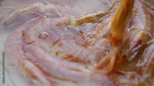 Fresh whole pink prawns or shrimps boiling in a pot of water in a close up view in full frame in a seafood and dietary concept photo