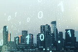 Double exposure of abstract virtual binary code hologram on Los Angeles city skyscrapers background. Database and programming concept