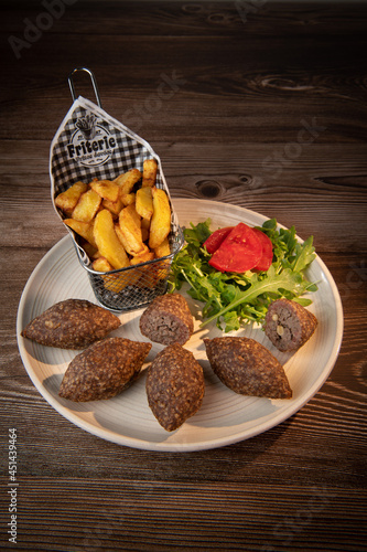 Traditional kebbe and pita bread on big round plate in lebanese restaurant. High quality photo