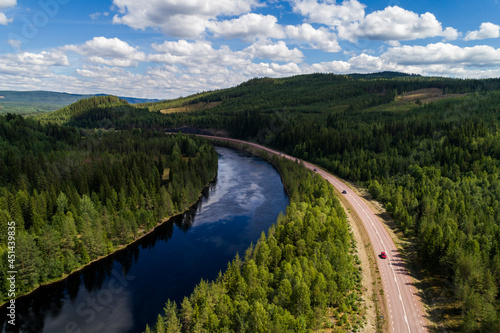 High angle aerial view of river and road running through forest and mountainous landscape in northern Sweden photo