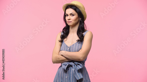 Offended woman in straw hat looking at camera isolated on pink.