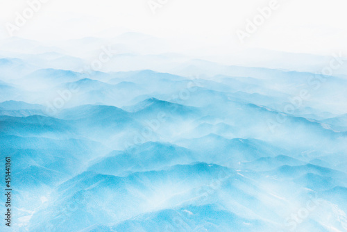 Aerial view of distant mountains layers range in morning mist. Meditation and zen landscape.