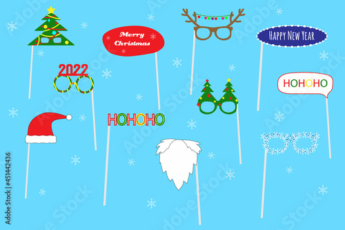 Christmas party photo booth set. Winter Holidays party concept for selfie. Glasses, Xmas trees, Santa beard, 2022, antlers, Santa hat on sticks