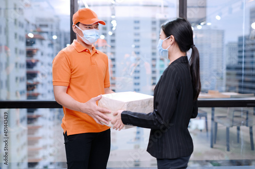 A shipping professional is delivering a parcel to a customer at her office.