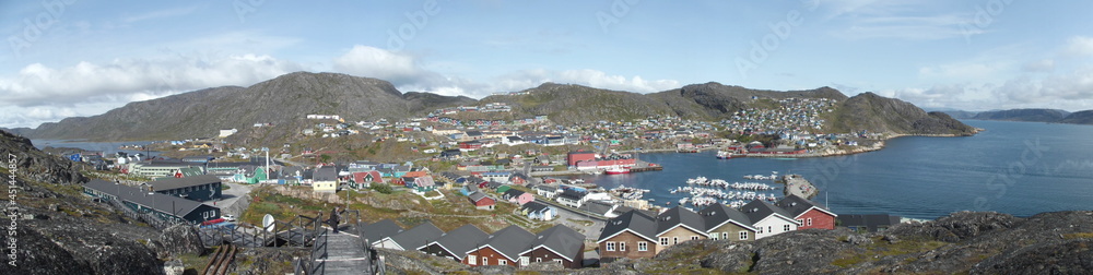 View from one of the many hills of Qaqortog, Iceland, towards the colorful houses of the city, on the left the inland lake Tasersuaq, on the right the fjord