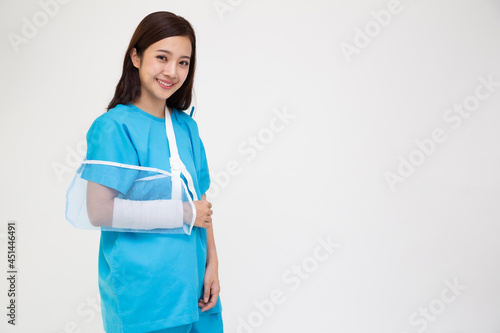 Young Asian woman wearing patient outfits and put on a soft splint due to a broken arm isolated on white background, Personal accident concept