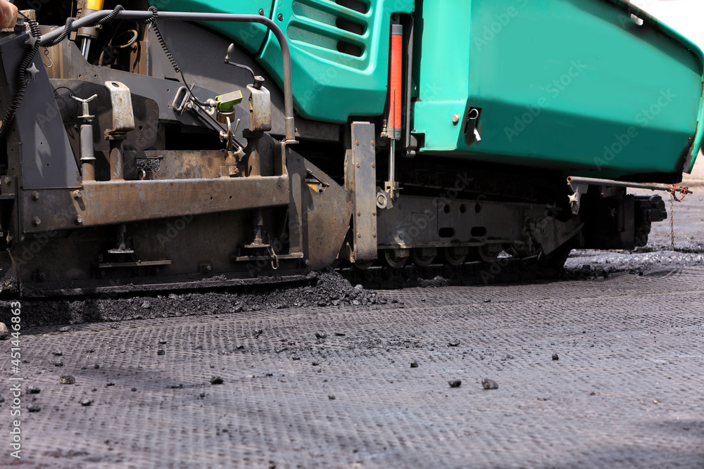 Asphalt paver working on street, closeup. Road repair Asphalt paver working on street, closeup. Road repair