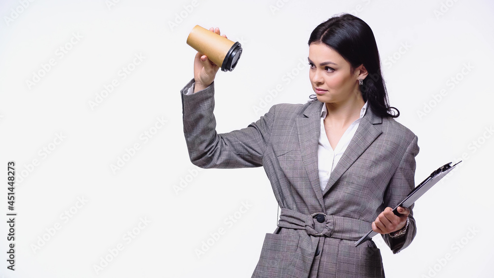 Businesswoman with clipboard looking at empty paper cup isolated on white. Businesswoman with clipboard looking at empty paper cup isolated on white.