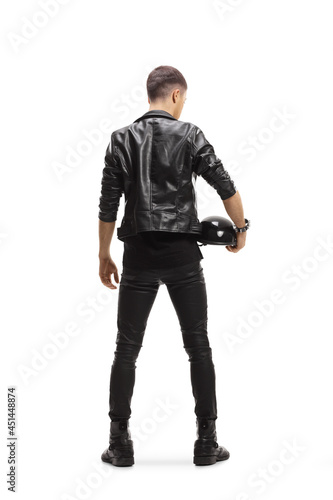 Full length rear view shot of a biker in a leather jacket holding a helmet