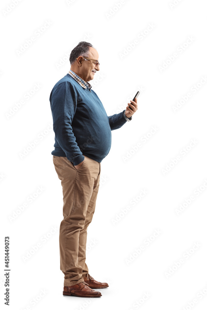 Full length profile shot of an elderly man standing and using a mobile phone Full length profile shot of an elderly man standing and using a mobile phone