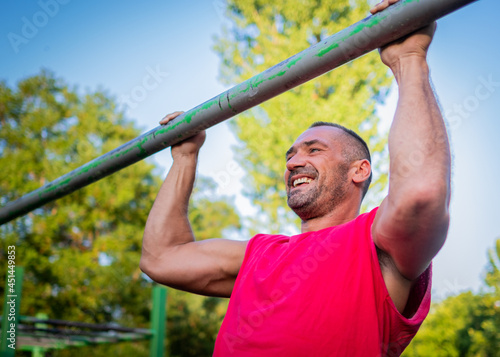 young man smiling and doing pull ups