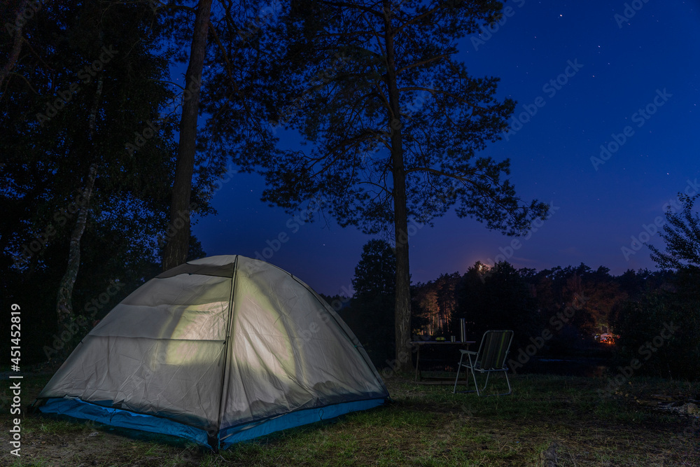 Tourist tent lighting at night in wildness