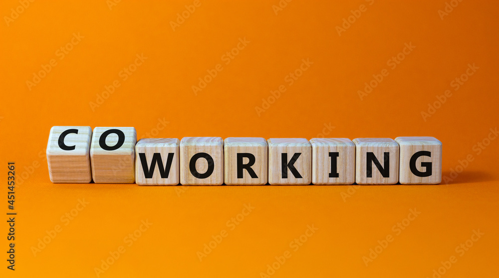Working or coworking symbol. Turned a cube and changed the word 'working' to 'coworking'. Beautiful orange background. Business and working or coworking concept. Copy space. Working or coworking symbol. Turned a cube and changed the word 'working' to 'coworking'. Beautiful orange background. Business and working or coworking concept. Copy space.