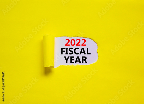 2022 fiscal new year symbol. Words '2022 fiscal year' appearing behind torn yellow paper. Beautiful yellow background. Business, 2022 fiscal new year concept, copy space.