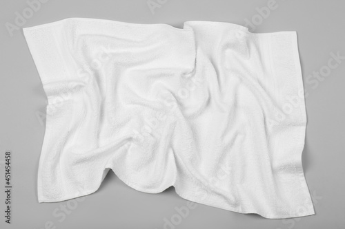 Crumpled white beach towel on light grey background, top view