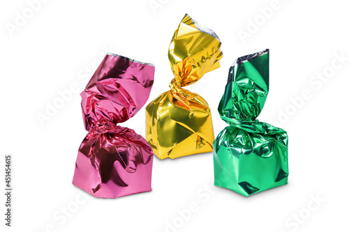 Three candies in pink, yellow and green wrapper isolated on white background