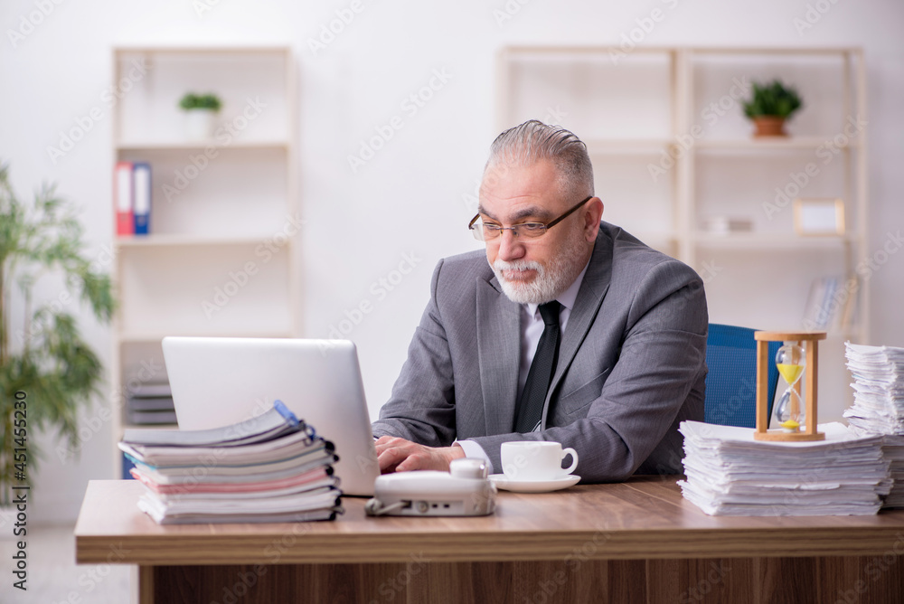 Old male employee in time management concept Old male employee in time management concept