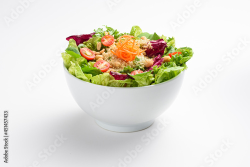 Healthy cooked quinoa, grated carrot and cherry tomato salad, in white bowl, isolated