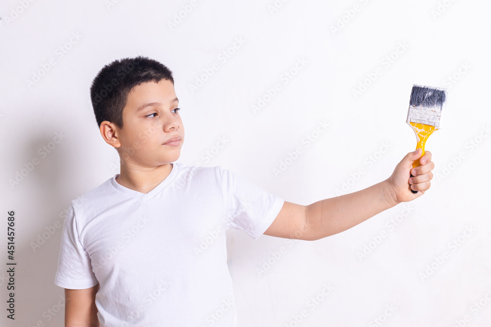 Hispanic boy points with paint brush Hispanic boy points with paint brush