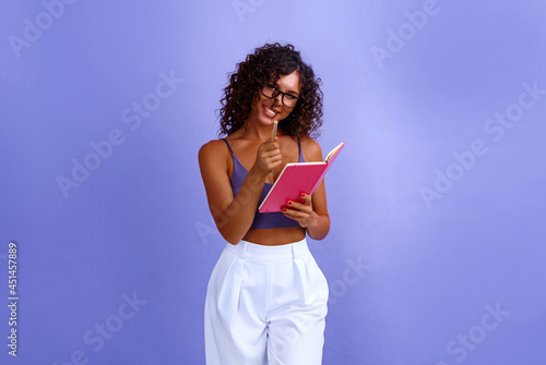 snapshot of happy cheerful expressive and satisfied black african american woman. back to school concept. woman student with note with notepad in hands