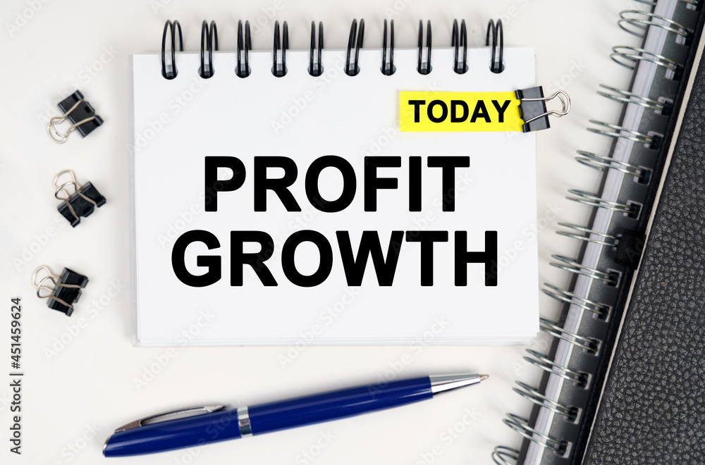 On the table is a pen and a notebook with inscriptions - Today and PROFIT GROWTH On the table is a pen and a notebook with inscriptions - Today and PROFIT GROWTH