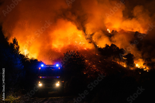 Un camión de bomberos delante de las llamas en un incendio forestal en Galicia, España. 