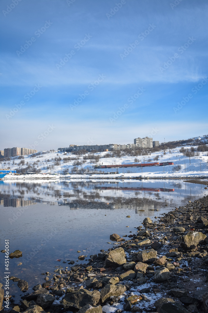 train on the background of snow-capped mountains on the background of the sky filmed from the water