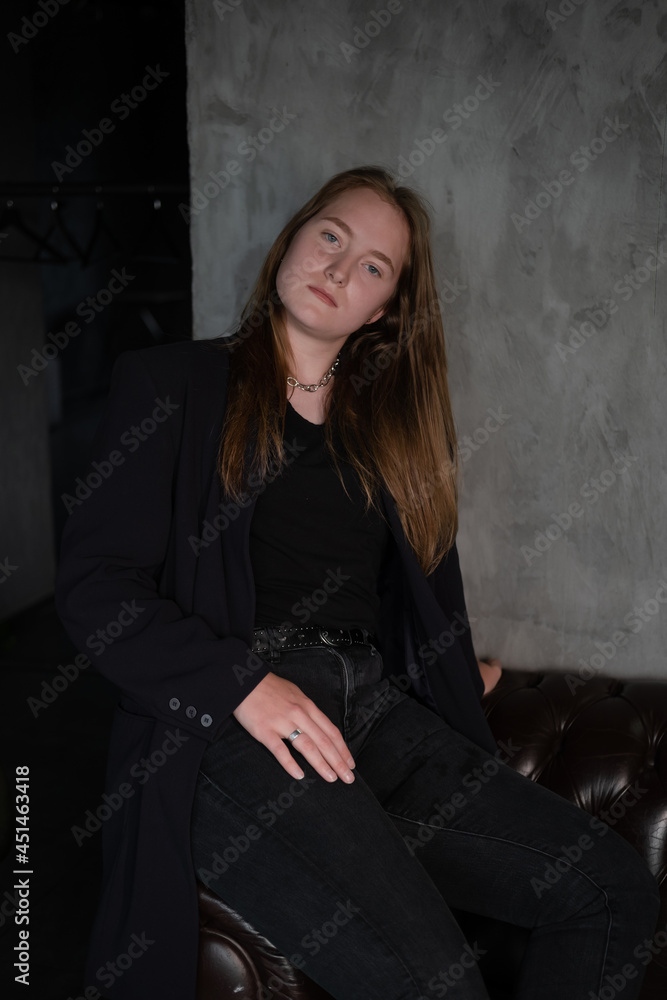 portrait of beautiful confident brunette woman in black in grey dark room. business woman. feminine. millennial people. stylish fashion clothes portrait of beautiful confident brunette woman in black in grey dark room. business woman. feminine. millennial people. stylish fashion clothes