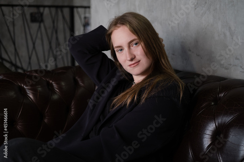 portrait of confident serious brunette woman in black clothes on dark background. femininity