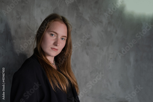 portrait of confident serious brunette woman in black clothes on dark background. femininity © OliaVesna