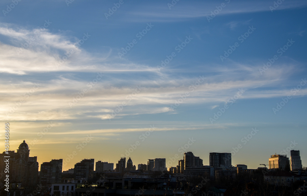Panorama view of Kyiv cityscape with silhouette of buildings against sunset sky, Ukraine