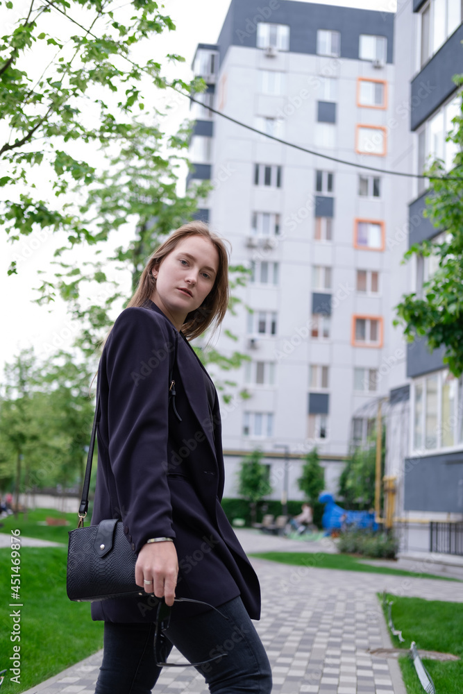 pretty brunette woman on background of bright modern buildings. feminine. millennial people. lady on walk