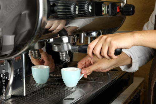 Barista making espresso using professional coffee machine  closeup