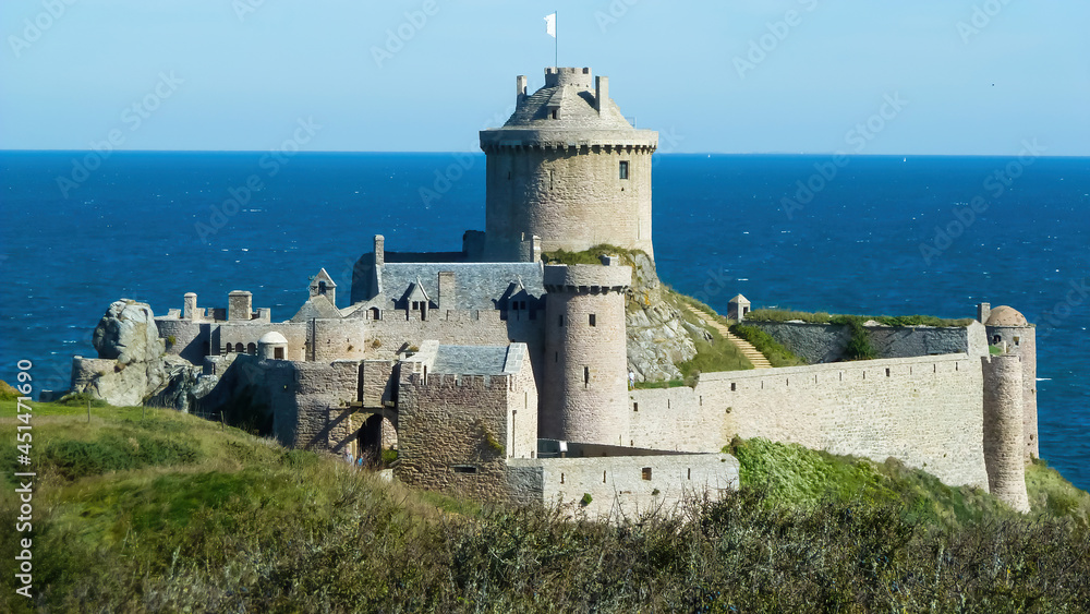 View on medieval sandstone castle from 13th century on cliff at atlantic ocean against dizzy sky - Fort la latte, Cap Frehel, France View on medieval sandstone castle from 13th century on cliff at atlantic ocean against dizzy sky - Fort la latte, Cap Frehel, France