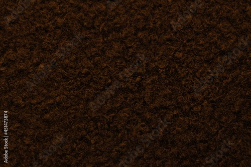 Brown astrakhan background from warm woolen fabric