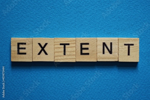 gray word extent in small square wooden letters with black font on a blue background