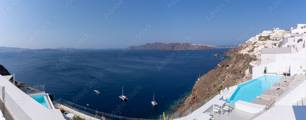 Panoramic view of Oia town in Santorini island with old whitewashed houses and traditional blue dome churches, Greece Greek landscape on a sunny day