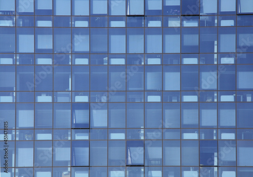 Geometry and abstract reflection of the blue facade. The exterior of modern offices: structure with glass windows. © Pamela Ranya