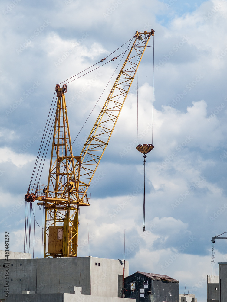 Tower crane is a rotary crane of the boom type with an arrow fixed in the upper part of a vertically located tower, on the construction site of a high-rise building Tower crane is a rotary crane of the boom type with an arrow fixed in the upper part of a vertically located tower, on the construction site of a high-rise building