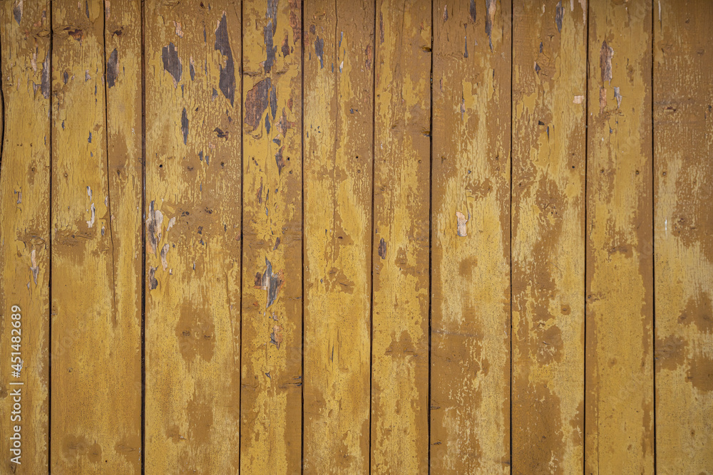 Old wood paneling with yellow paint chipping away Old wood paneling with yellow paint chipping away