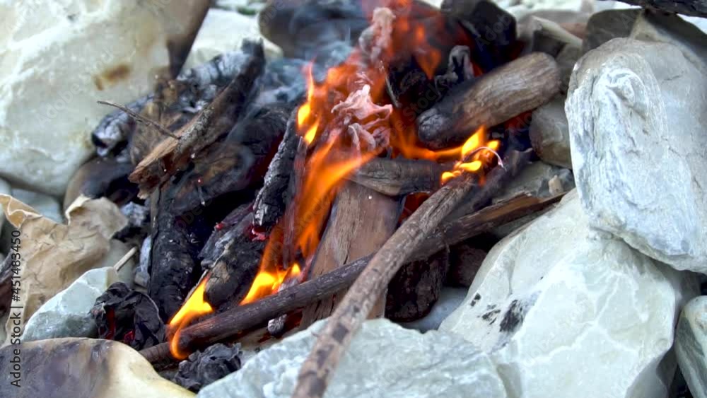 A burning bonfire on the stones. Hot fire. Firewood and sticks. Close-up. Flame and smoke. Fire for a kebab. Rest of the tourist. Waste incineration. Resting-place. A burning bonfire on the stones. Hot fire. Firewood and sticks. Close-up. Flame and smoke. Fire for a kebab. Rest of the tourist. Waste incineration. Resting-place.