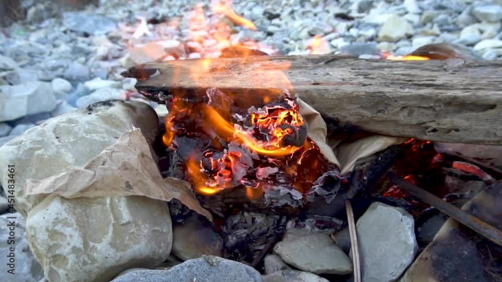 A burning bonfire on the stones. Hot fire. Firewood and sticks. Close-up. Flame and smoke. Fire for a kebab. Rest of the tourist. Waste incineration. Resting-place. A burning bonfire on the stones. Hot fire. Firewood and sticks. Close-up. Flame and smoke. Fire for a kebab. Rest of the tourist. Waste incineration. Resting-place.